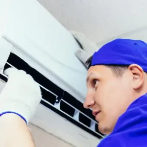 young-worker-blue-baseball-cap-gloves-inspects-maintains-air-conditioner-room_230115-2169 (1)